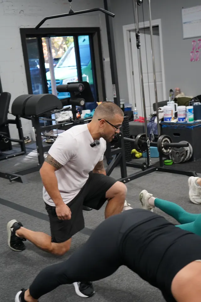 Coach demonstrating a lunge during a training session at Visualize Fitness